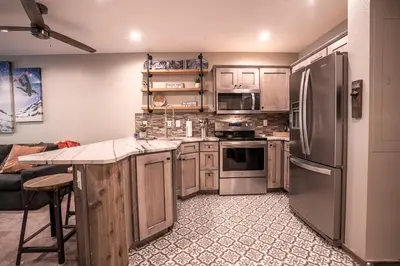a kitchen with stainless steel appliances and a couch at Striking and Unique Zephyr Mountain Lodge Condo - second floor walkout condo in Winter Park