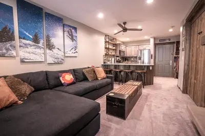 a living room with a couch and a kitchen at Striking and Unique Zephyr Mountain Lodge Condo - second floor walkout condo in Winter Park
