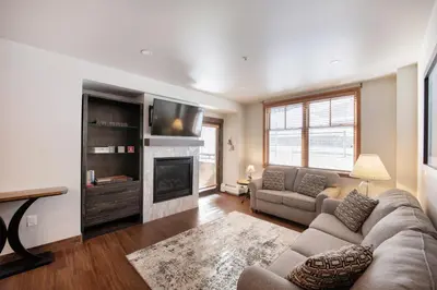 a living room with a couch and a fireplace at Warm & Cozy Zephyr Mountain Lodge condo with Arapahoe Forest and Corridor Ski Trail Views condo in Winter Park