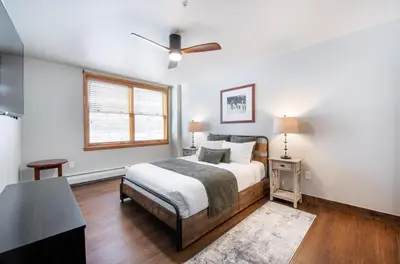 a white bedroom with a bed and a window at Warm & Cozy Zephyr Mountain Lodge condo with Arapahoe Forest and Corridor Ski Trail Views condo in Winter Park