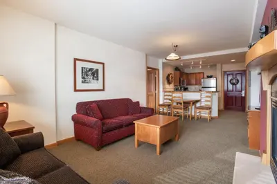 a living room with a couch and a table at Great Ski-In Ski-Out Zephyr Mountain Lodge Condo with Lovely Balcony Views condo in Winter Park