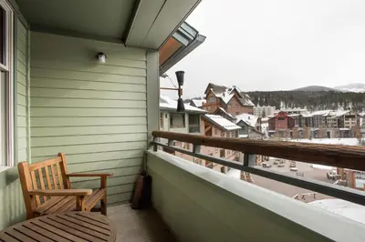 a balcony with a chair and a view of a town at Great Ski-In Ski-Out Zephyr Mountain Lodge Condo with Lovely Balcony Views condo in Winter Park