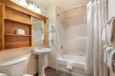 a bathroom with a sink and a tub and a toilet at Great Ski-In Ski-Out Zephyr Mountain Lodge Condo with Lovely Balcony Views condo in Winter Park