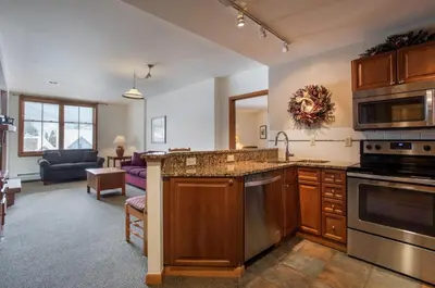 a kitchen with a sink and a living room at Great Ski-In Ski-Out Zephyr Mountain Lodge Condo with Lovely Balcony Views condo in Winter Park