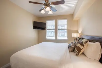a bedroom with a white bed and a ceiling fan at Charming Fraser Crossing Founders Pointe condo with Easy Gondola Access condo in Winter Park