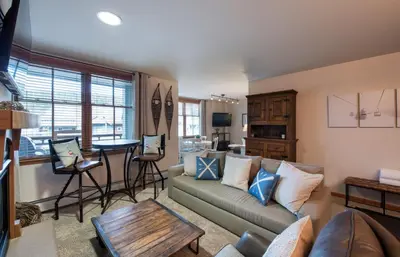 a living room with a couch and a table at Lovely Zephyr Mountain Lodge Condo with Cozy Alcove - Close to Mountain condo in Winter Park
