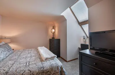 a bedroom with a bed and a flat screen tv at Lovely Zephyr Mountain Lodge Condo with Cozy Alcove - Close to Mountain condo in Winter Park