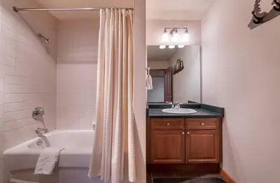 a bathroom with a tub and a toilet and a sink at Lovely Zephyr Mountain Lodge Condo with Cozy Alcove - Close to Mountain condo in Winter Park