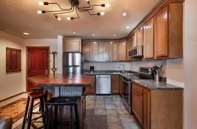a kitchen with wooden cabinets and a counter top at Lovely Zephyr Mountain Lodge Condo with Cozy Alcove - Close to Mountain condo in Winter Park