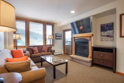 a living room with a couch and a fireplace at Remodeled Zephyr Mountain Lodge condo with upgraded furnishings and Slope Side View condo in Winter Park