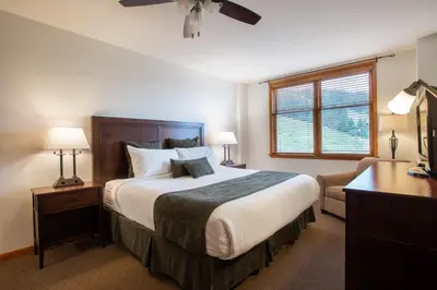 a bedroom with a bed and a desk and a window at Remodeled Zephyr Mountain Lodge condo with upgraded furnishings and Slope Side View condo in Winter Park