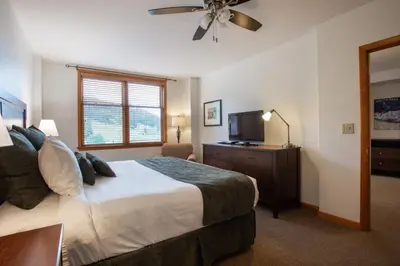 a bedroom with a bed and a flat screen tv at Remodeled Zephyr Mountain Lodge condo with upgraded furnishings and Slope Side View condo in Winter Park