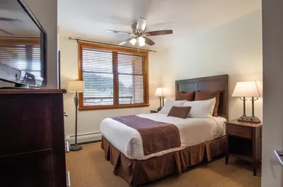 a bedroom with a bed and a ceiling fan at Remodeled Zephyr Mountain Lodge condo with upgraded furnishings and Slope Side View condo in Winter Park