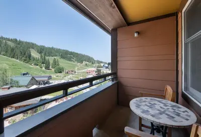 a balcony with a table and a view of a mountain at Zephyr Mountain Lodge Premium-Rated 2505 in Winter Park