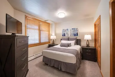 a bedroom with a bed with a television and a dresser at Zephyr Mountain Lodge Premium-Rated 2505 in Winter Park