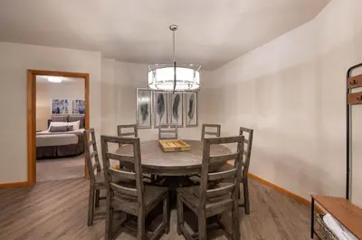a dining room with a table and chairs and a bed at Zephyr Mountain Lodge Premium-Rated 2505 in Winter Park