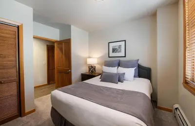 a bedroom with a large bed with blue pillows at Zephyr Mountain Lodge Premium-Rated 2505 in Winter Park