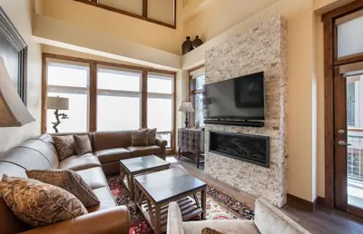 a living room with a couch and a fireplace at Exquisite Zephyr Mountain Lodge condo with 2 king en suite's condo in Winter Park