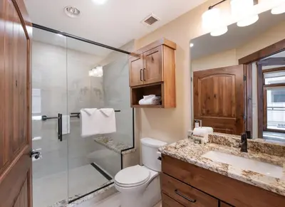 a bathroom with a shower and a toilet and a sink at Exquisite Zephyr Mountain Lodge condo with 2 king en suite's condo in Winter Park