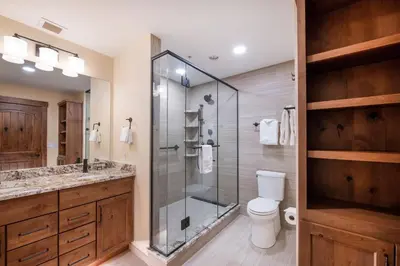 a bathroom with a glass shower and a toilet at Exquisite Zephyr Mountain Lodge condo with 2 king en suite's condo in Winter Park