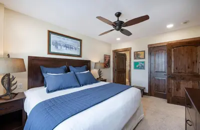 a bedroom with a bed and a ceiling fan at Exquisite Zephyr Mountain Lodge condo with 2 king en suite's condo in Winter Park