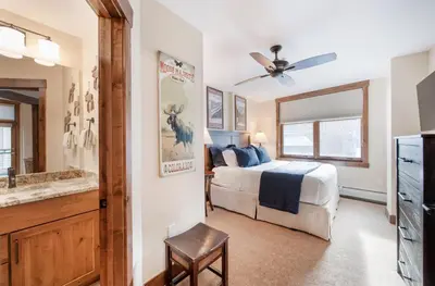 a bedroom with a bed and a bathroom with a television at Exquisite Zephyr Mountain Lodge condo with 2 king en suite's condo in Winter Park