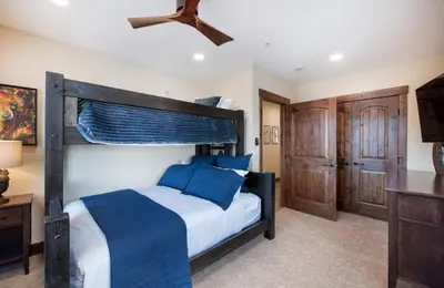 a bedroom with a large bed with blue pillows at Exquisite Zephyr Mountain Lodge condo with 2 king en suite's condo in Winter Park