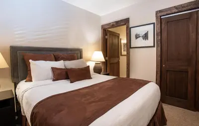 a bedroom with a large bed with brown and white pillows at Outstanding Zephyr Mountain Lodge Condo with Ski Slope Views condo in Winter Park