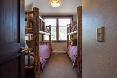 a room with two bunk beds and a window at Outstanding Zephyr Mountain Lodge Condo with Ski Slope Views condo in Winter Park