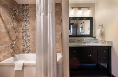 a bathroom with a shower and a tub and a sink at Outstanding Zephyr Mountain Lodge Condo with Ski Slope Views condo in Winter Park