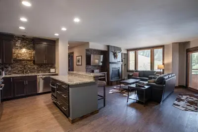 a kitchen and living room with a couch and a table at Outstanding Zephyr Mountain Lodge Condo with Ski Slope Views condo in Winter Park