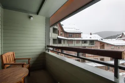 a balcony with a wooden bench and a view at Zephyr Mountain Lodge Premium-Rated 1506 in Winter Park