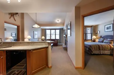a room with a kitchen and a bedroom with a bed at Zephyr Mountain Lodge Select-Rated 1604 in Winter Park