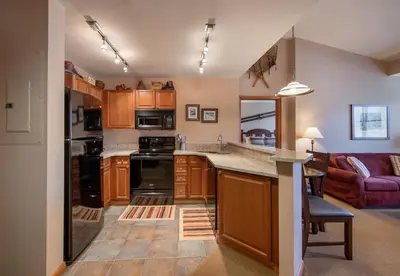 a kitchen with wooden cabinets and a counter top at Zephyr Mountain Lodge Select-Rated 1604 in Winter Park