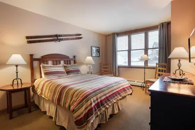 a bedroom with a bed and a desk with two lamps at Zephyr Mountain Lodge Select-Rated 1604 in Winter Park