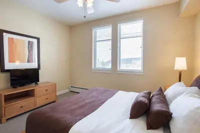 a bedroom with a bed and a flat screen tv at Comfortable Fraser Crossing Founders Pointe Condo Near Gondola with Onsite Ski Storage condo in Winter Park