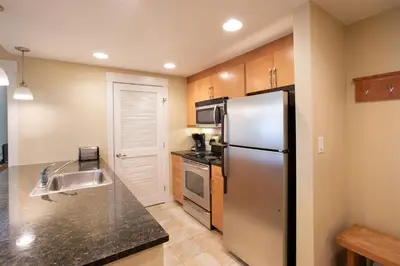 a kitchen with a stainless steel refrigerator and a sink at Comfortable Fraser Crossing Founders Pointe Condo Near Gondola with Onsite Ski Storage condo in Winter Park