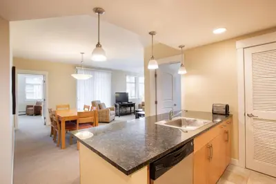 a kitchen with a sink and a living room at Comfortable Fraser Crossing Founders Pointe Condo Near Gondola with Onsite Ski Storage condo in Winter Park