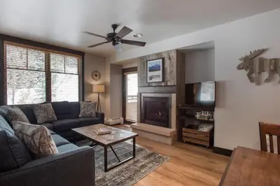 a living room with a couch and a fireplace at Cozy Zephyr Mountain Lodge condo with sweeping views of Arapahoe National Forest condo in Winter Park