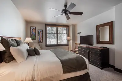 a bedroom with a bed and a ceiling fan at Cozy Zephyr Mountain Lodge condo with sweeping views of Arapahoe National Forest condo in Winter Park
