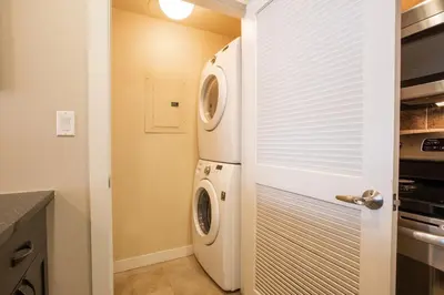 a laundry room with a washer and dryer next to a door at Townhome Style Fraser Crossing Founders Pointe Condo with Upgraded Furnishings and washer dryer condo in Winter Park
