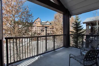 a balcony with two chairs and a view of a building at Townhome Style Fraser Crossing Founders Pointe Condo with Upgraded Furnishings and washer dryer condo in Winter Park