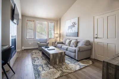 a living room with a couch and a table at Cozy Zephyr Mountain Lodge Condo with Spectacular View of Gondola condo in Winter Park