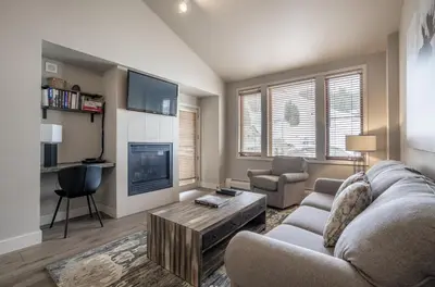 a living room with a couch and a tv at Cozy Zephyr Mountain Lodge Condo with Spectacular View of Gondola condo in Winter Park
