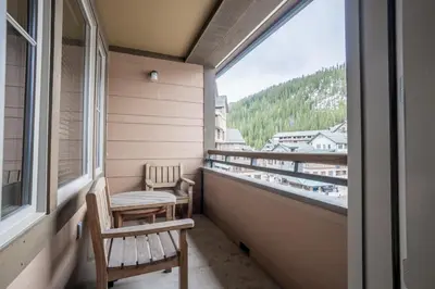 a balcony with two chairs and a window at Cozy Zephyr Mountain Lodge Condo with Spectacular View of Gondola condo in Winter Park
