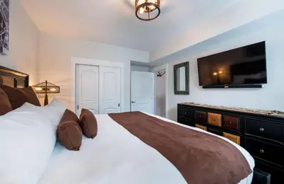 a bedroom with a bed with a television on the wall at Deluxe Fraser Crossing Founders Pointe Condo with Ski Storage and washer dryer condo in Winter Park