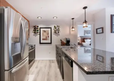 a kitchen with a refrigerator and a counter top at Deluxe Fraser Crossing Founders Pointe Condo with Ski Storage and washer dryer condo in Winter Park