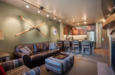a living room with a leather couch and a bar at Stunning Zephyr Mountain Lodge Condo Overlooking The Village Plaza condo in Winter Park