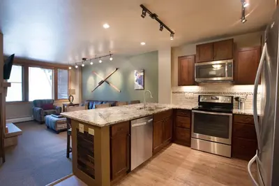 a kitchen with a sink and a stove top oven at Stunning Zephyr Mountain Lodge Condo Overlooking The Village Plaza condo in Winter Park
