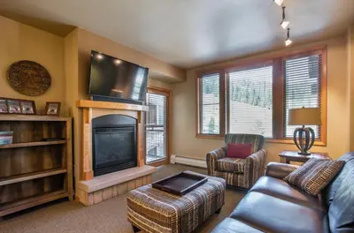 a living room with a couch and a fireplace at Stunning Zephyr Mountain Lodge Condo Overlooking The Village Plaza condo in Winter Park